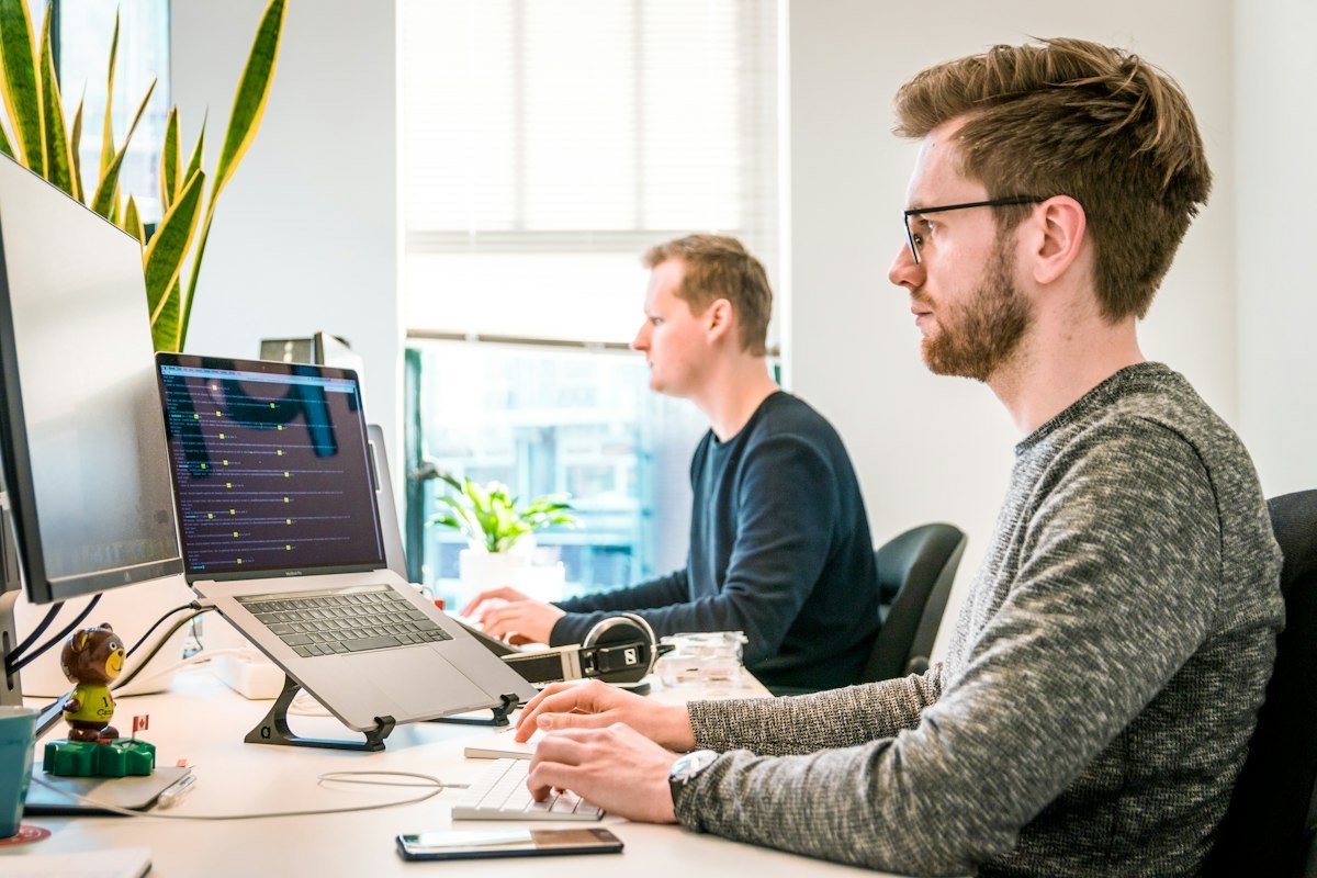 IT consultants working together on laptops in a modern office